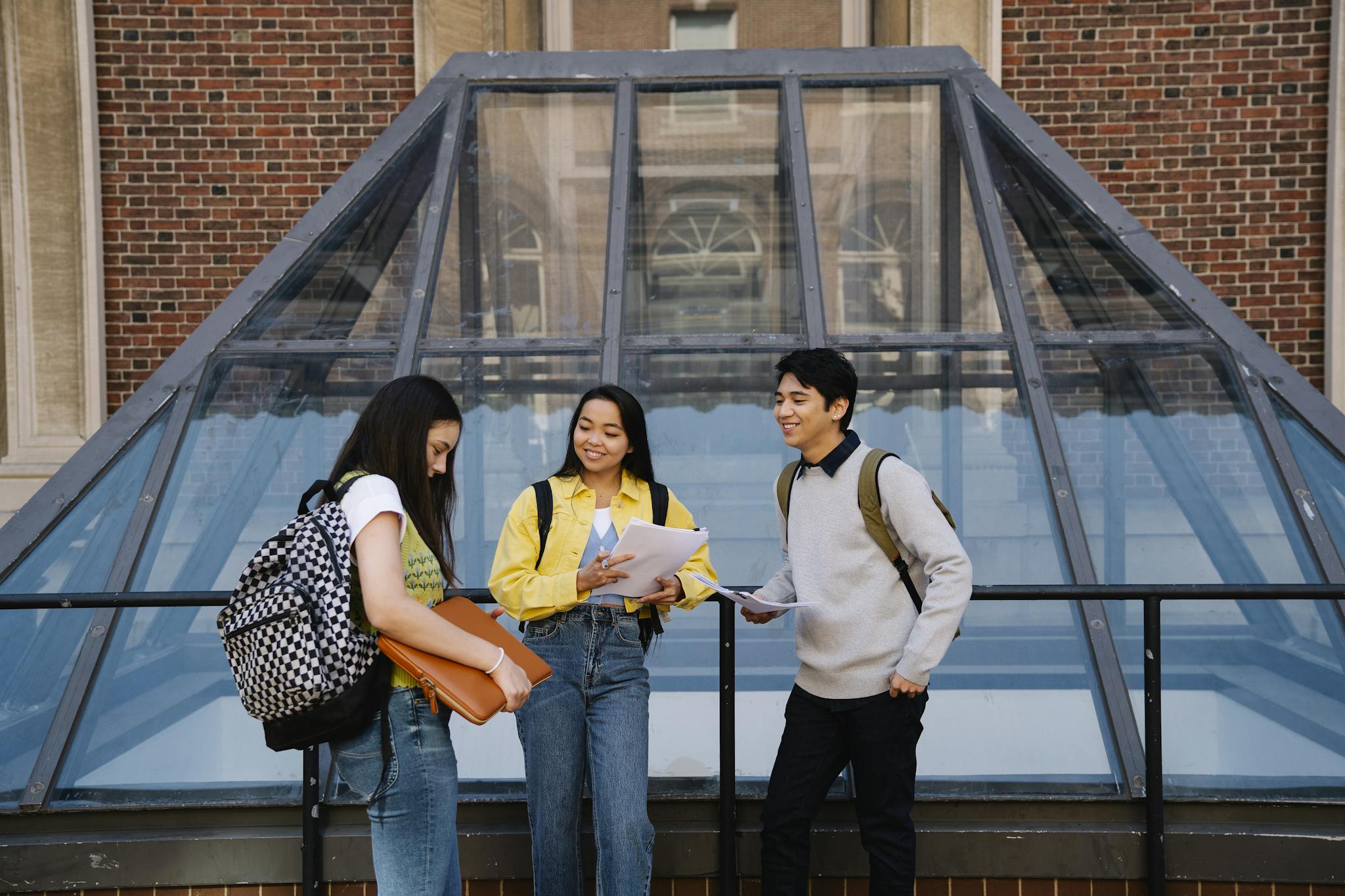 Students talking and studying together at a university campus outdoors.